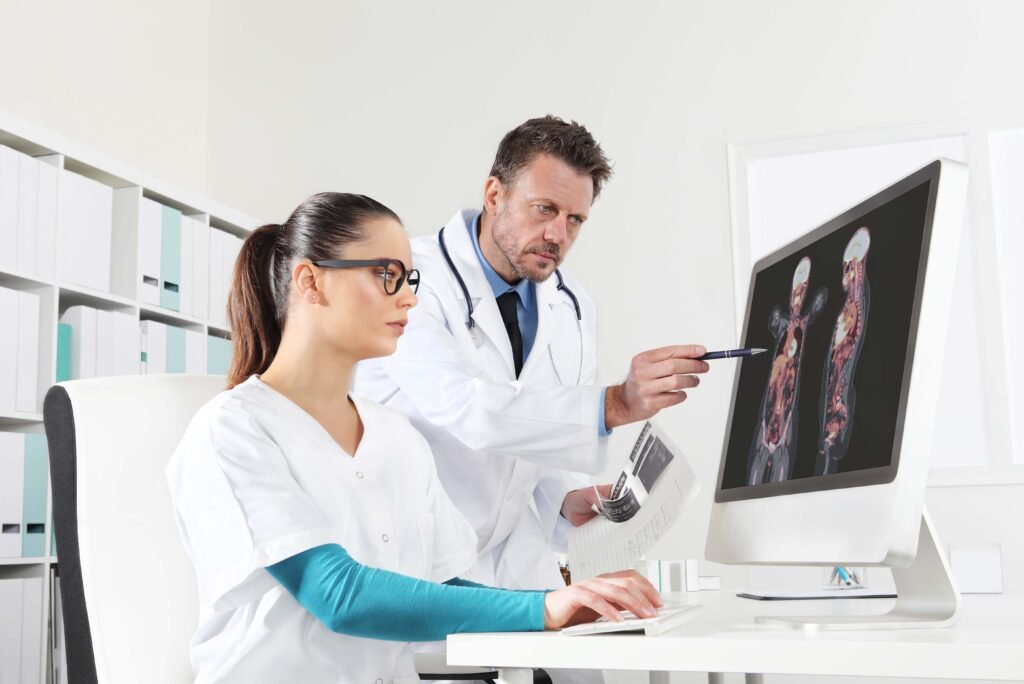 m, analisam exame pet-ct na tela do computador. foto ilustra o texto sobre programa de residência médica em medicina Nuclear